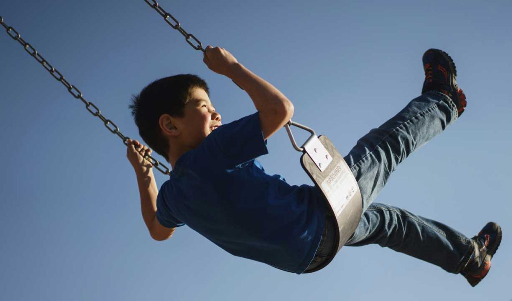 Hard to focus child: boy swinging on a swing